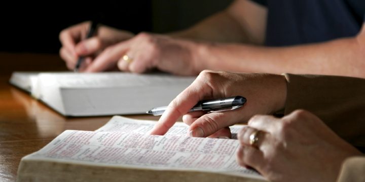 A couple studies the Holy Bible together - Can be during devotional time or with a bible study group.
